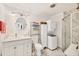 Bathroom with white vanity, toilet, shower, and stacked washer/dryer at 690 Percheron, Nokomis, FL 34275
