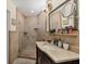 Elegant bathroom with a walk-in shower, vanity, and decorative mirror at 690 Percheron, Nokomis, FL 34275