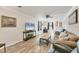 Living room featuring hardwood floors, comfortable seating, and a large TV at 690 Percheron, Nokomis, FL 34275