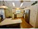 Galley kitchen with stainless steel appliances and light wood cabinets at 701 S Green Cir, Venice, FL 34285