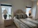 Bedroom with wood furniture, bedding, and two windows at 723 Locarno Dr, Venice, FL 34285