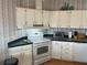 White kitchen cabinets, appliances, and green countertops at 723 Locarno Dr, Venice, FL 34285