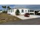 White single-wide manufactured home with green accents and mature shrubs at 788 Cervina Dr, Venice, FL 34285