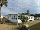 Rear view of the manufactured home showing landscaping and utilities at 788 Cervina Dr, Venice, FL 34285