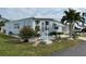 Side view of light blue manufactured home with landscaping at 827 Baveno Dr, Venice, FL 34285