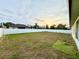 The backyard with a large grassy area enclosed by a white vinyl fence at 8307 Glover Ave, North Port, FL 34291