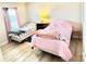 Cozy bedroom featuring two twin beds, wood-look floors, and a bright window with pink curtains at 8307 Glover Ave, North Port, FL 34291