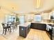 Kitchen featuring a breakfast bar with dark cabinetry and tile flooring with the dining area in view at 8307 Glover Ave, North Port, FL 34291