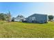 Green grassy backyard with golf cart and trees at 869 Cascade Ct, Englewood, FL 34223