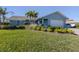 Light blue house with a well-manicured lawn and palm trees at 900 Osprey St, Venice, FL 34285