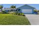 House exterior showcasing a light blue facade, a white garage door, and landscaping at 900 Osprey St, Venice, FL 34285
