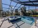 Inviting pool and spa with a screened enclosure and patio furniture at 900 Osprey St, Venice, FL 34285