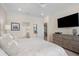 King-size bed, dresser, and view into bathroom and kitchen at 10058 Crooked Creek Dr # 201, Venice, FL 34293