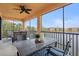 Spacious screened lanai with lake view, dining furniture, and ceiling fan at 10058 Crooked Creek Dr # 201, Venice, FL 34293