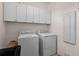 Laundry room with washer, dryer, and overhead storage cabinets at 10058 Crooked Creek Dr # 201, Venice, FL 34293