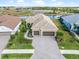 Aerial view of a two-story house with a three-car garage and landscaped yard at 10984 Trevino St, Englewood, FL 34223