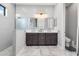 Elegant bathroom with double vanity, large mirror, and walk-in shower at 10984 Trevino St, Englewood, FL 34223