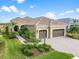 Single-story home with tile roof, two-car garage, and landscaped yard at 10984 Trevino St, Englewood, FL 34223