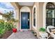 Inviting front entry with blue door, brick walkway, and potted plants at 10984 Trevino St, Englewood, FL 34223