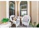 Relaxing front porch with wicker chairs and plants at 10984 Trevino St, Englewood, FL 34223