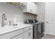 Laundry room with washer, dryer, and extra storage at 10984 Trevino St, Englewood, FL 34223