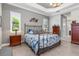 Bright main bedroom with metal bed frame, window seating, and wood nightstands at 10984 Trevino St, Englewood, FL 34223