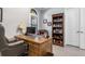 Home office with large desk, comfortable chair, and built-in shelving at 10984 Trevino St, Englewood, FL 34223