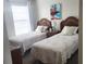 Bright bedroom with twin beds and beach-themed bedding at 112 Jose Gaspar Dr # 112, Englewood, FL 34223