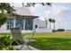 Tranquil community lawn with a bench and clubhouse in the background at 1206 Tuscany Blvd, Venice, FL 34292