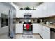 Modern kitchen featuring stainless steel appliances and white cabinetry at 12391 Amica Loop, Venice, FL 34293