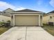 Attached garage with light beige door and driveway at 12460 Shimmering Oak Cir, Venice, FL 34293
