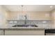 Kitchen island with granite countertop and double stainless steel sink at 12460 Shimmering Oak Cir, Venice, FL 34293