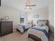 Guest bedroom with twin beds, dresser, and ceiling fan at 12950 Basilica Dr, Venice, FL 34293