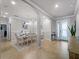 Bright dining room with white table and chairs, and access to the entryway at 12950 Basilica Dr, Venice, FL 34293