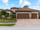 Two-story house with three-car garage and a brick driveway at 12950 Basilica Dr, Venice, FL 34293