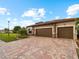 Two-story house with three-car garage, stone accents, and landscaping at 12950 Basilica Dr, Venice, FL 34293