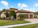 Two-story house with three-car garage, stone accents and landscaping at 12950 Basilica Dr, Venice, FL 34293