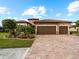 Two-story house with three-car garage and a brick driveway at 12950 Basilica Dr, Venice, FL 34293