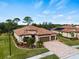 Two-story house with tile roof, paver driveway, and mature trees at 12950 Basilica Dr, Venice, FL 34293