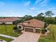 Single-story home with tile roof, three-car garage, and landscaped yard at 12950 Basilica Dr, Venice, FL 34293