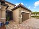 Brown double-car garage with stone accents and walkway at 12950 Basilica Dr, Venice, FL 34293