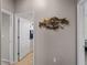 Bright hallway with access to bathroom and bedrooms, featuring decorative wall art at 12950 Basilica Dr, Venice, FL 34293