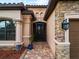Front entrance with stone accents, a screened door, and a walkway at 12950 Basilica Dr, Venice, FL 34293
