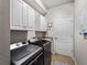 Bright laundry room, washer, dryer, cabinets, and granite countertop at 12950 Basilica Dr, Venice, FL 34293