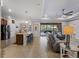 Open living space with kitchen island, grey sofas, and pool view at 12950 Basilica Dr, Venice, FL 34293