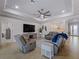 Spacious living room with grey sofas and a large TV at 12950 Basilica Dr, Venice, FL 34293