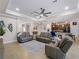 Open concept living area with grey sofas and kitchen view at 12950 Basilica Dr, Venice, FL 34293