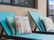 Teal lounge chairs with butterfly pillows near the pool at 12950 Basilica Dr, Venice, FL 34293