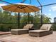 Comfortable lounge chairs under an umbrella by the pool at 12950 Basilica Dr, Venice, FL 34293