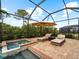 Relaxing spa with lounge chairs and umbrella in screened enclosure at 12950 Basilica Dr, Venice, FL 34293